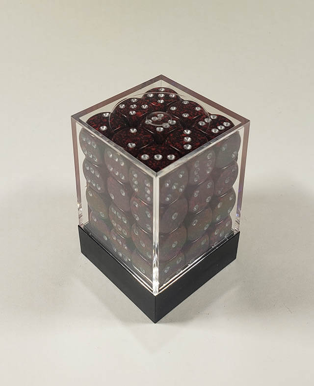 A close up of the Chessex specked silver volcano 12mm d6 dice set in its package.