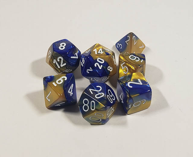 A close up of the Chessex Gemini Blue and Gold polyhedral dice set.