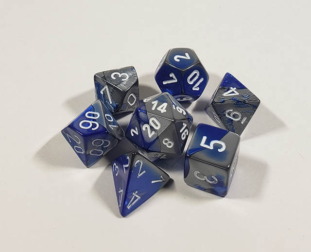 A close up of the Chessex Gemini Blue and Steel polyhedral dice set.