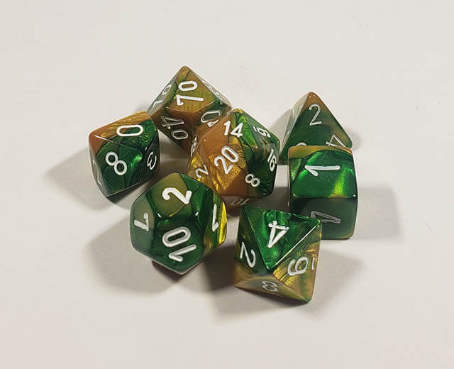A close up of the Chessex Gemini Gold and Green polyhedral dice set.