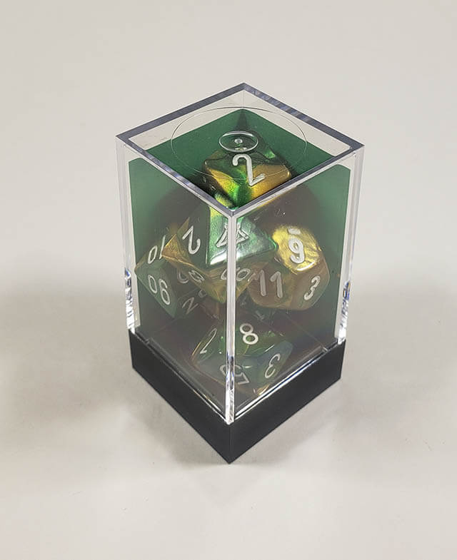 A close up of the Chessex Gemini Gold and Green polyhedral dice set in its package.