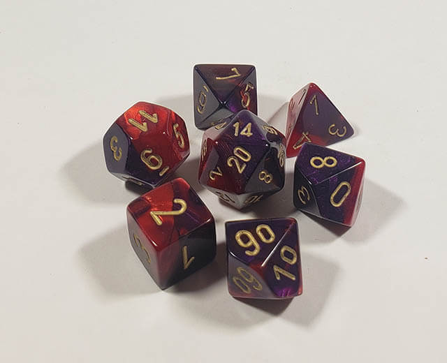 A close up of the Chessex Gemini Purple and Red polyhedral dice set.