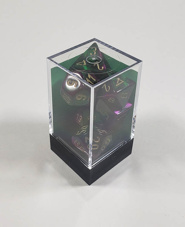 A close up of the Chessex Gemini Greena and Purple polyhedral dice set in its package.