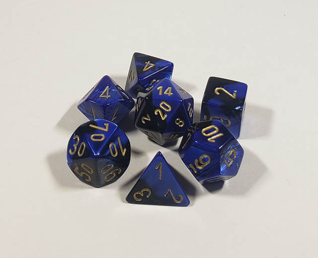 A close up of the Chessex Gemini Black and blue polyhedral dice set.