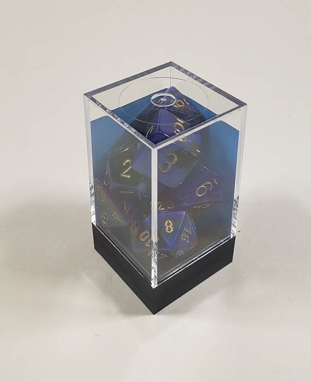 A close up of the Chessex Gemin Black and Blue polyhedral dice set in its package.