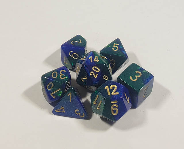 A close up of the Chessex Gemini Blue and Green polyhedral dice set.