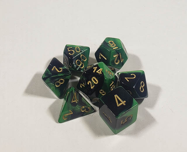 A close up of the Chessex Gemini Black and Green polyhedral dice set.