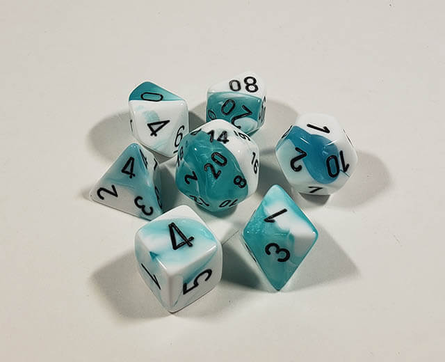 A close up of the Chessex Gemini Teal and White polyhedral dice set.