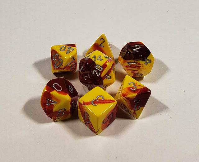 A close up of the Chessex Gemini Red and Yellow polyhedral dice set.