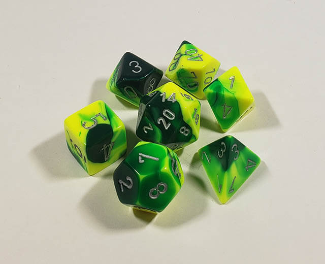 A close up of the Chessex Gemini Green and Yellow polyhedral dice set.