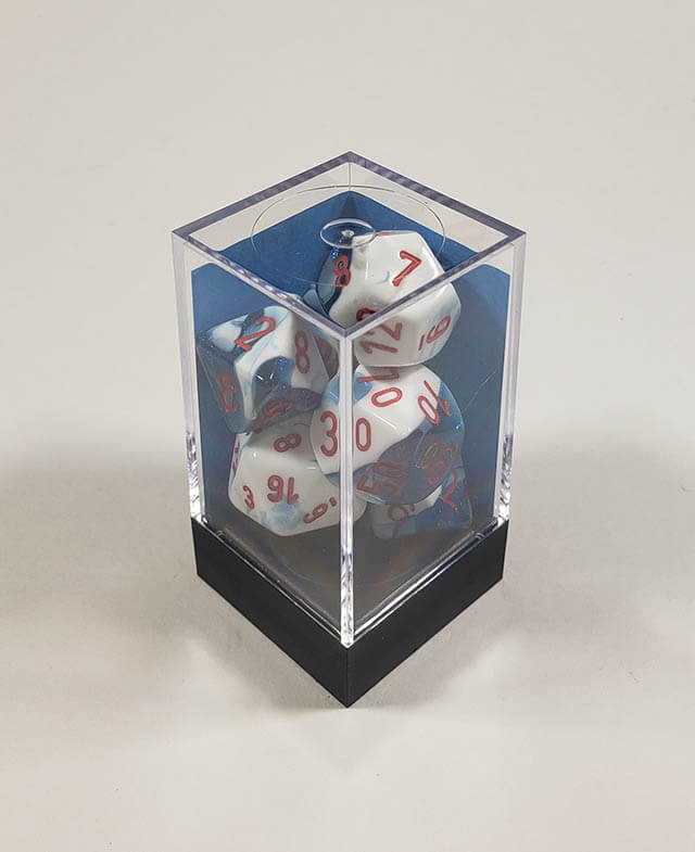 A close up of the Chessex Gemini Astra Blue and White polyhedral dice set in its package.