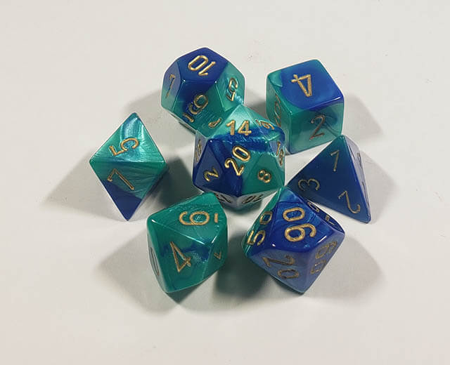 A close up of the Chessex Gemini Blue Teal polyhedral dice set.