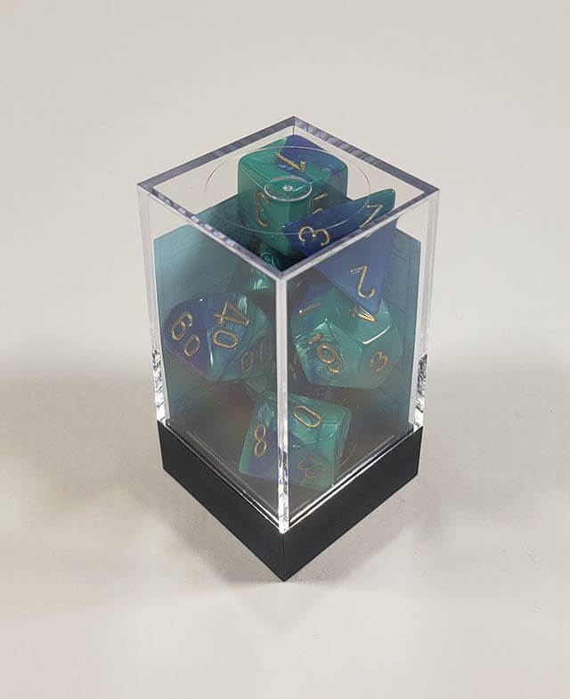 A close up of the Chessex Gemini Blue and Teal polyhedral dice set in its package.