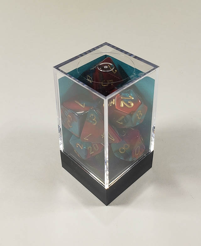 A close up of the Chessex Gemini Red and Teal polyhedral dice set in its package.