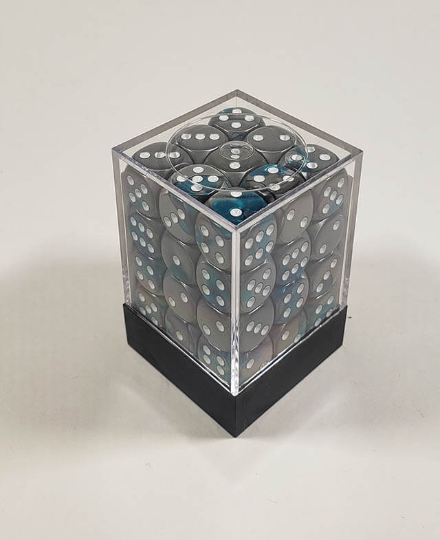A close up of the Chessex Gemini Steel and Teal 12mm d6 dice set in its package.