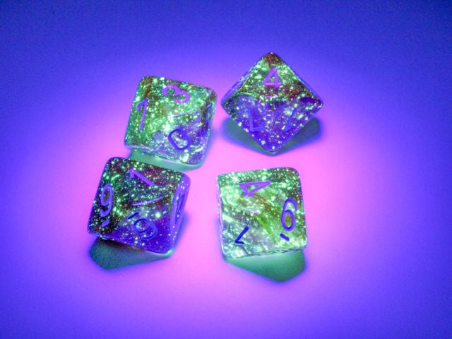 A close up of examples from the Nebula Primary with Blue 10 d10 dice set under a black light.