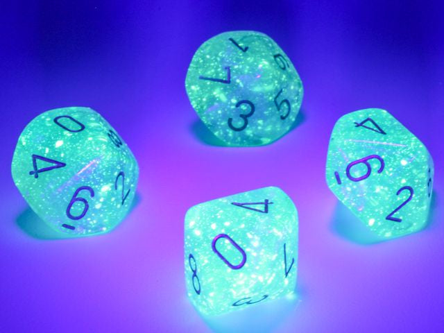 A close up of examples fromthe Chessex Borealis Teal with gold 10 d10 dice set under a blacklight.