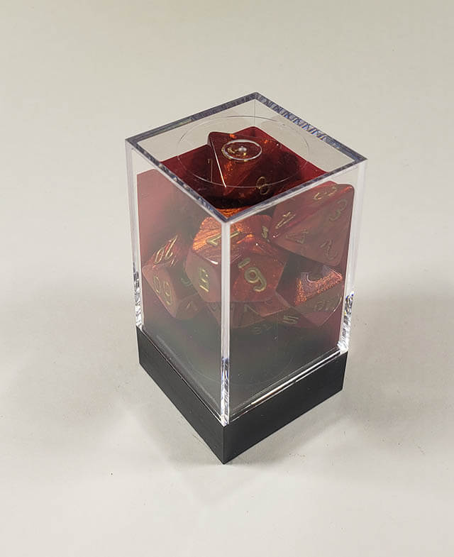 A close up of the Chessex Scarab Scarlet polyhedral dice set in its package.