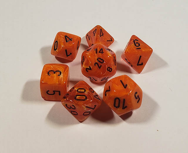 A close up of the Chessex Vortex Orange with Black Polyhedral dice set.