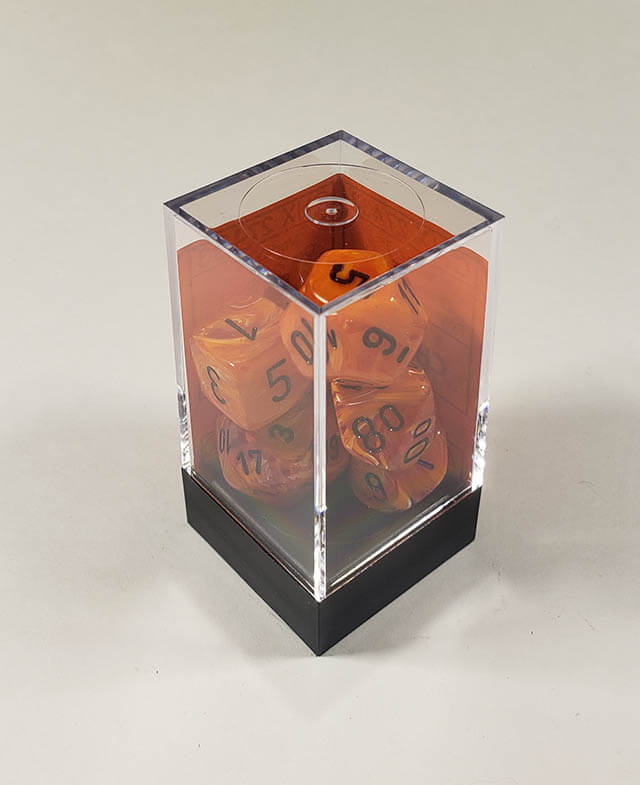 A close up of the Chessex vortex Orange with black polyhedral dice set in its package.