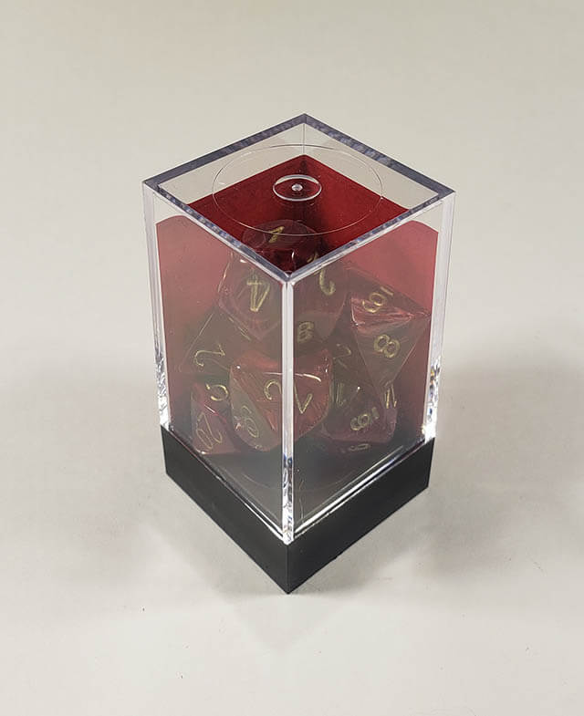 A close up of the Chessex Vortex Burgundy with gold polyhedral dice set in its package.