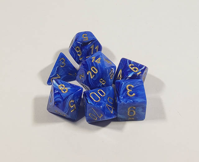 A close up of the Chessex vortex blue with gold polyhedral set.