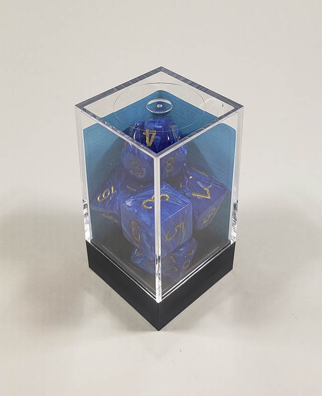 A close up of the Chessex vortex blue with gold polyhedral set in its package.