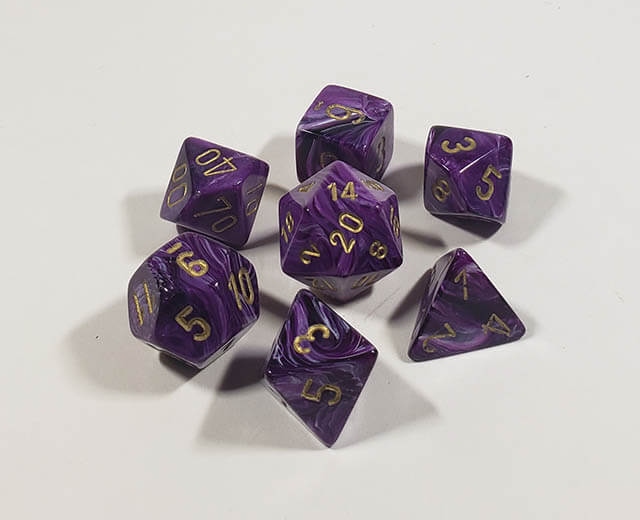A close up of the Chessex Vortex purple with gold polyhedral set.