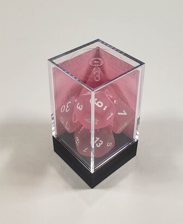 A close up of the Chessex Frosted Pink polyhedral dice set in its package.