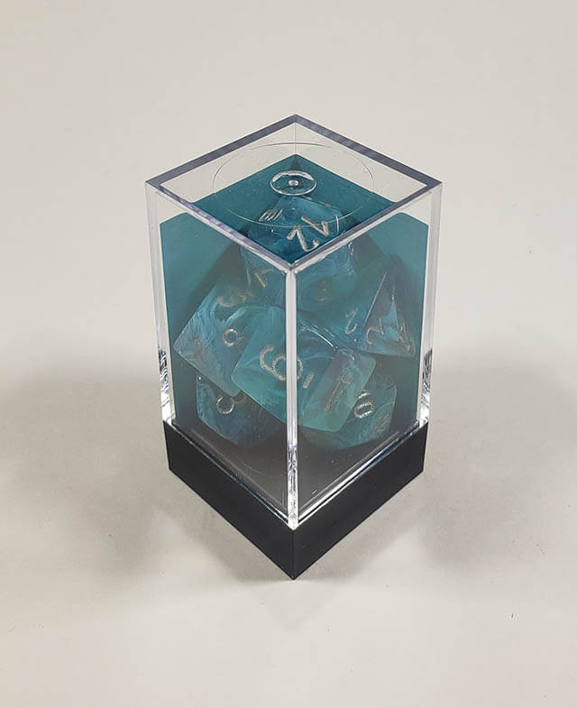 A close up of the Chessex Cirrus Aqua polyhedral dice set in its package.