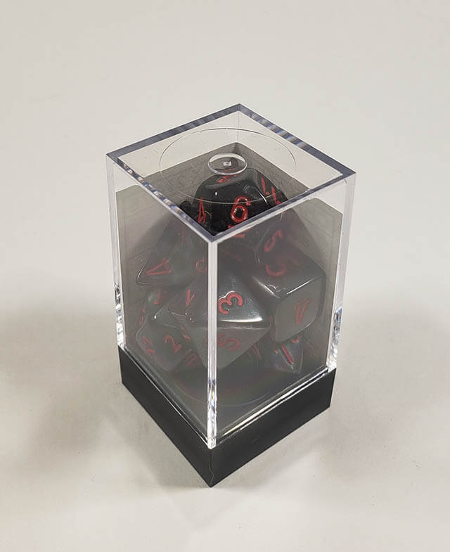 A close up of the Chessex Velvet black with red polyhedral dice set in its packaging.