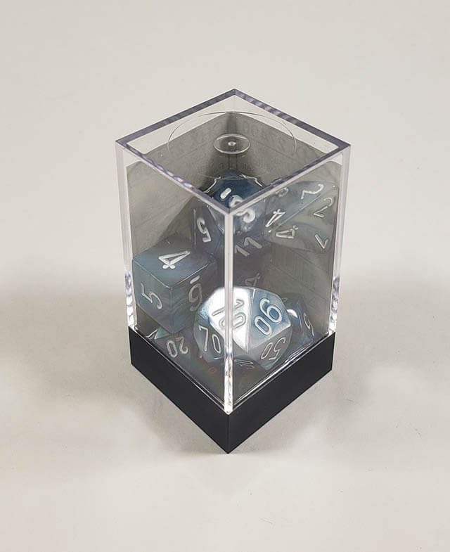 A close up of the Chessex Lustrous Slate polyhedral dice set in its package.