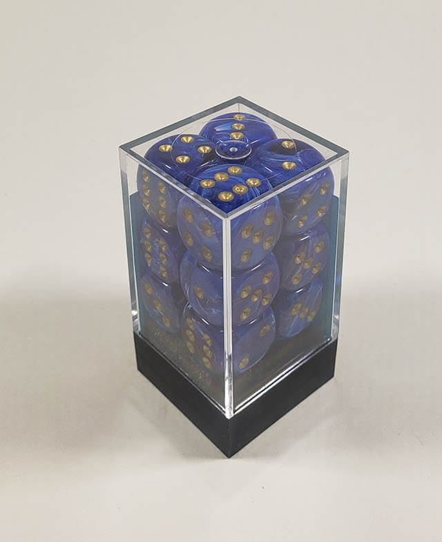 A close up of the Chessex vortex blue with gold 16mm d6 dice set in its package.
