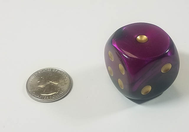 An example of the Chessex Gemini Black-Purple with gold 30mm d6 with a quarter for scale.