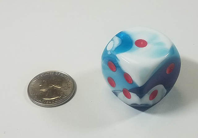 An example of the Chessex Gemini Astral Blue-White with red 30mm d6 with a quarter for scale.