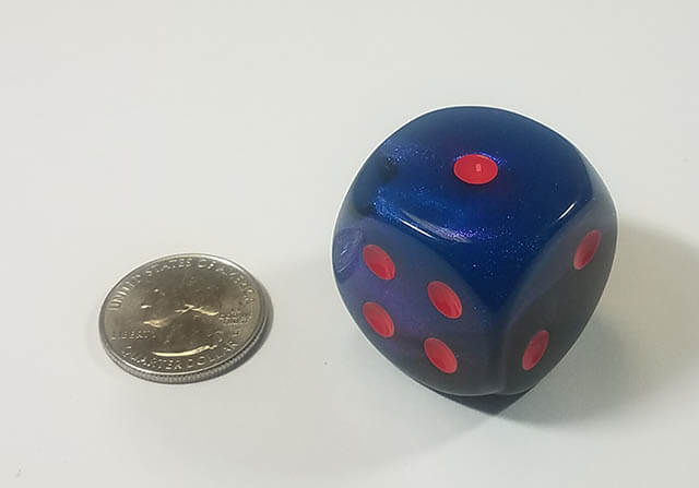 An example of the Chessex Gemini Black-Starlight with red 30mm d6 with a quarter for scale.
