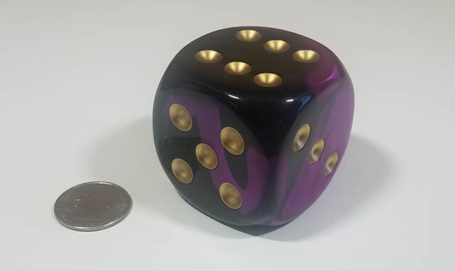 Swirled black and purple 50mm d6 with quarter for scale