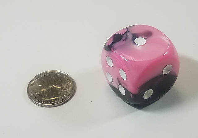 An example of the Chessex Gemini Black-Pink with white 30mm d6 with a quarter for scale.
