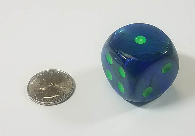An example of the Chessex Lusterous Dark Blue with Green 30mm d6 with a quarter for scale.