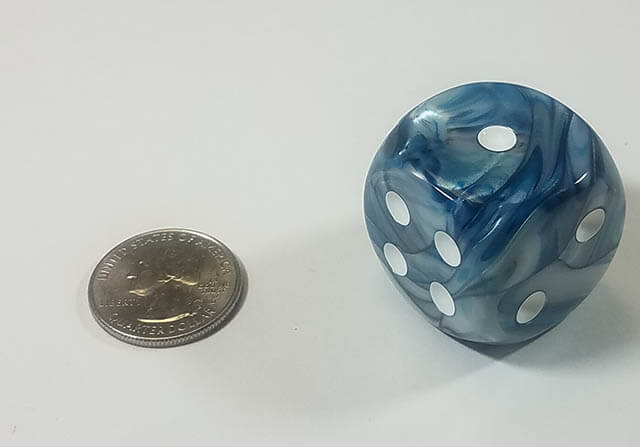 An example of the Chessex Lusterous Slate with white 30mm d6 with a quarter for scale.