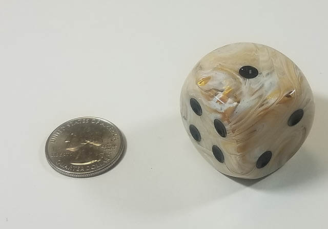 An example of the Chessex Marble Ivory with Black 30mm d6 with a quarter for scale.
