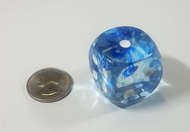 An example of the Chessex Nebula Dark Blue with white 30mm d6 with a quarter for scale.