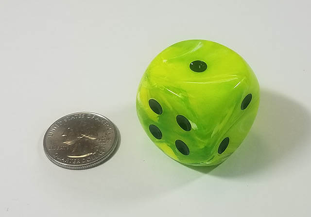 An example of the Chessex Vortex Bright Green with black 30mm d6 with a quarter for scale.