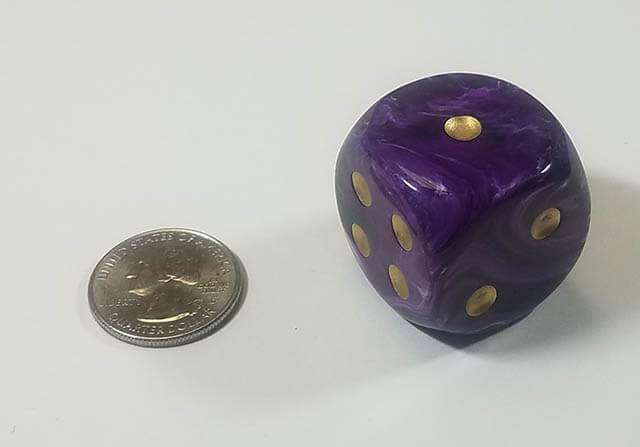 An example of the Chessex Vortex Purple with gold 30mm d6 with a quarter for scale.