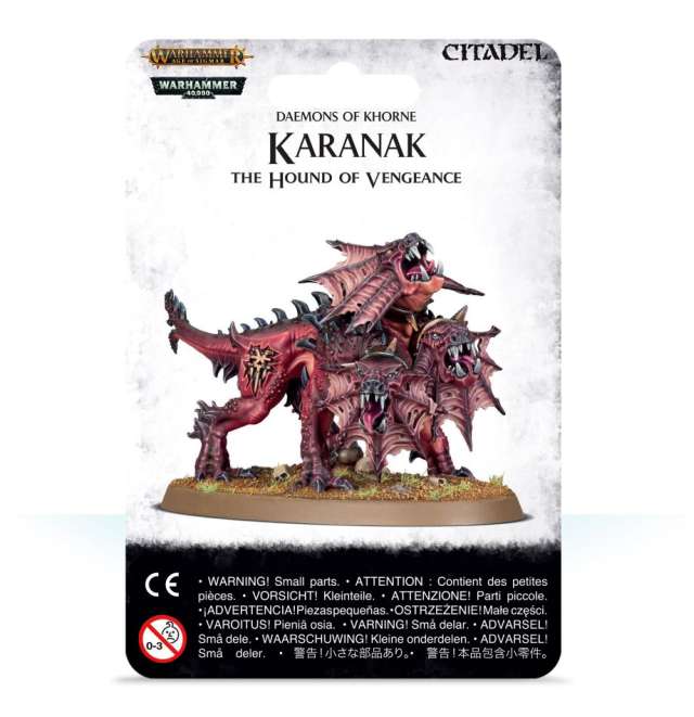 A product image showing the packaging for a miniature model kit named 'Karanak, The Hound of Vengeance' from the 'Blades of Khorne' series. The packaging displays the assembled model which is a three-headed hound, predominantly black and red in color, standing on a base.