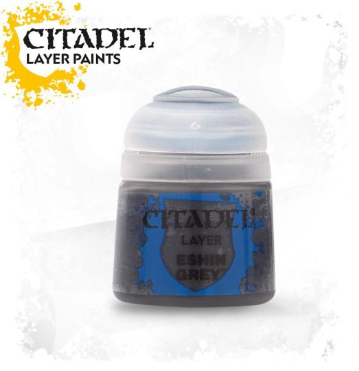 A pot of Citadel Layer acrylic paint in the color 'Eshin Grey'. The pot is labeled with the brand and product name, and is displayed against a yellow splatter background.