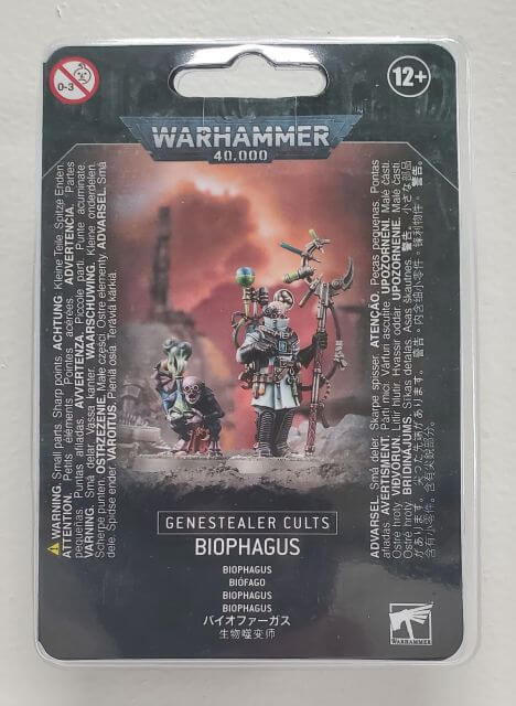 Packaged Genestealer Cults Biophagus miniature set from Warhammer 40,000, showing the character with a gun and a small creature on a card with the product information.