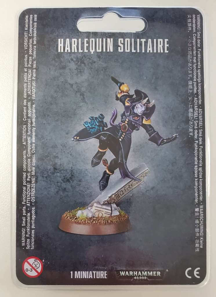 Packaging of Aeldari Solitaire miniature from Warhammer 40,000, featuring an illustrated character on a card with game-related text.
