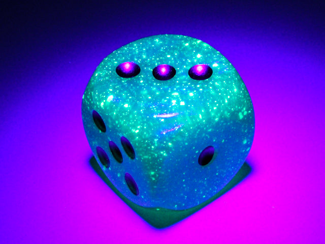 An example of the Chessex Borealis Luminary Light Green with gold 30mm d6 under a black light.
