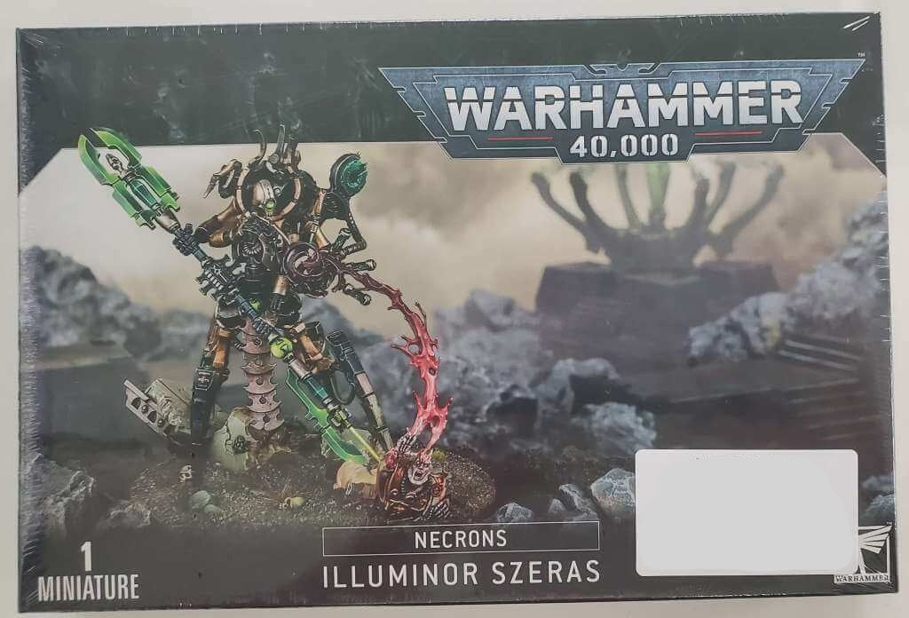 Packaging for Warhammer 40,000 featuring a miniature figure of Necron Illuminor Szeras, with green and black color scheme, on a base with citadel branding.